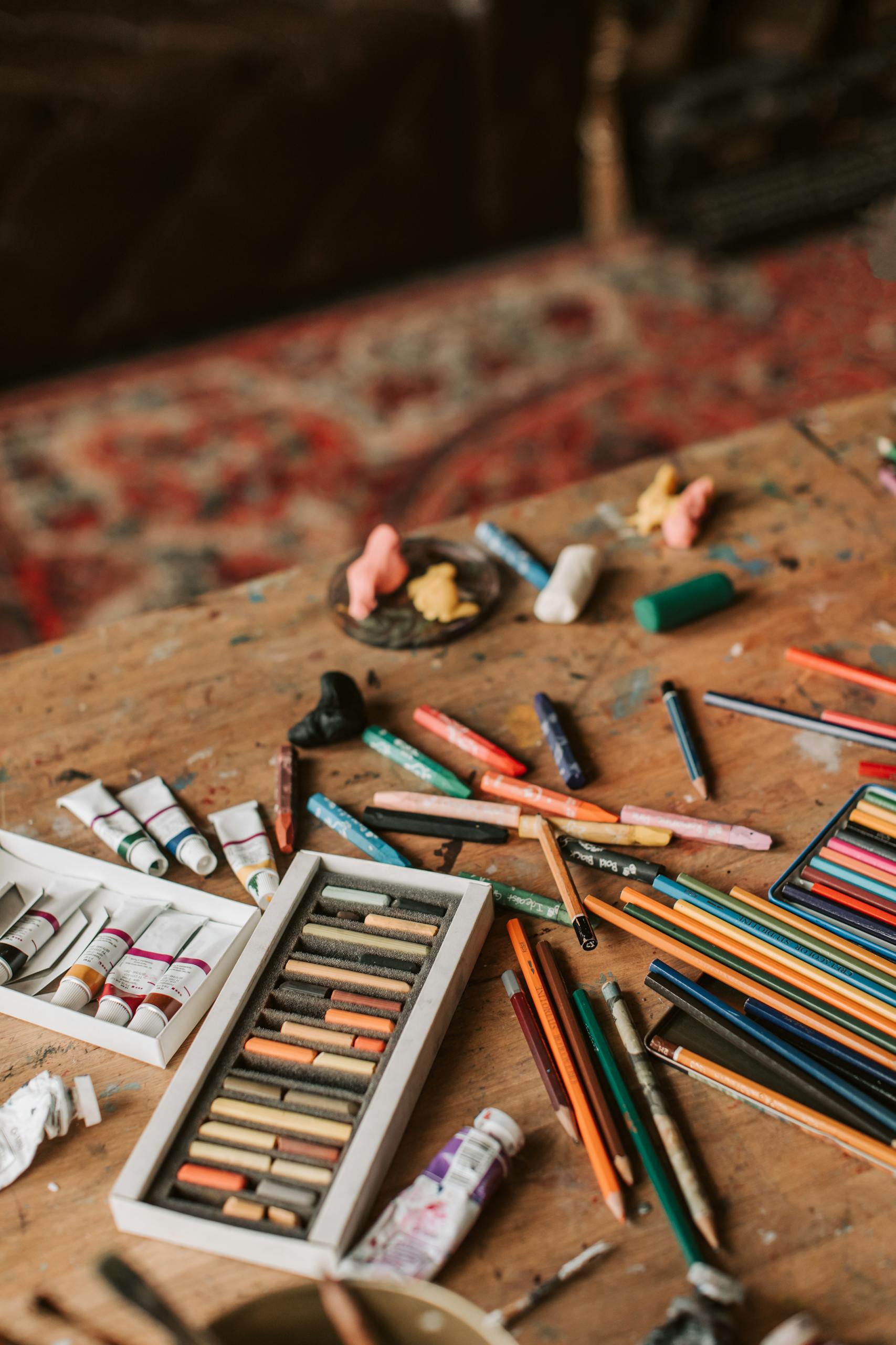 Colorful art supplies scattered on a wooden table, perfect for DIY crafts and creative projects.